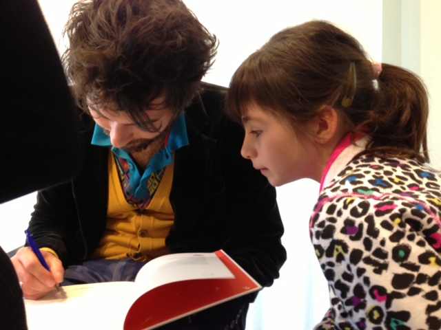 Kristof signeert Nina's boek, met een kleine tekening. Foto: Monique Wolvers